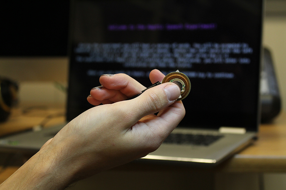 Language Sciences affiliate member David Marino holds the loonie-sized vibrating device used to enhance people's ability to understand speech.
