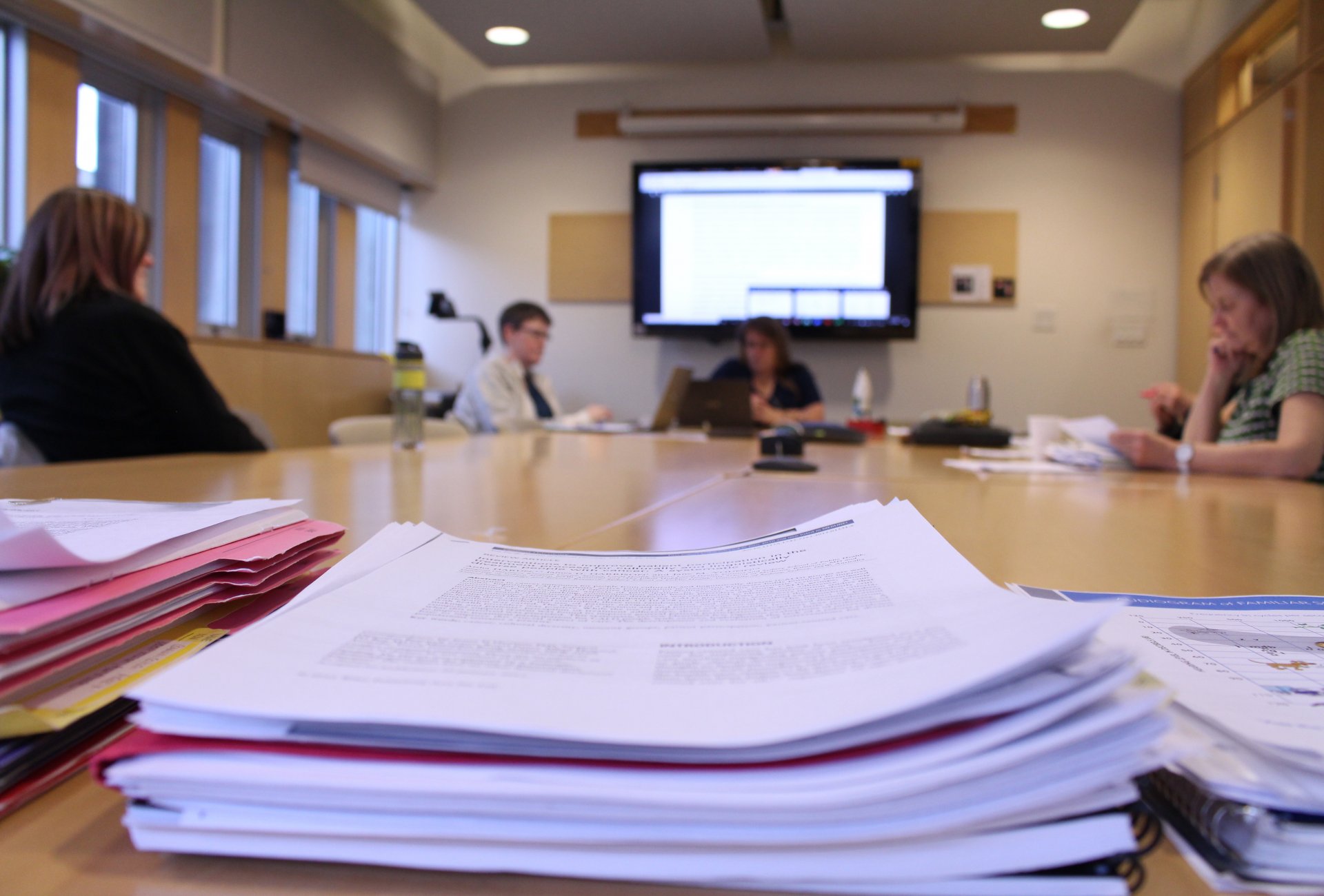 A picture of the HOLa team behind a stack of papers