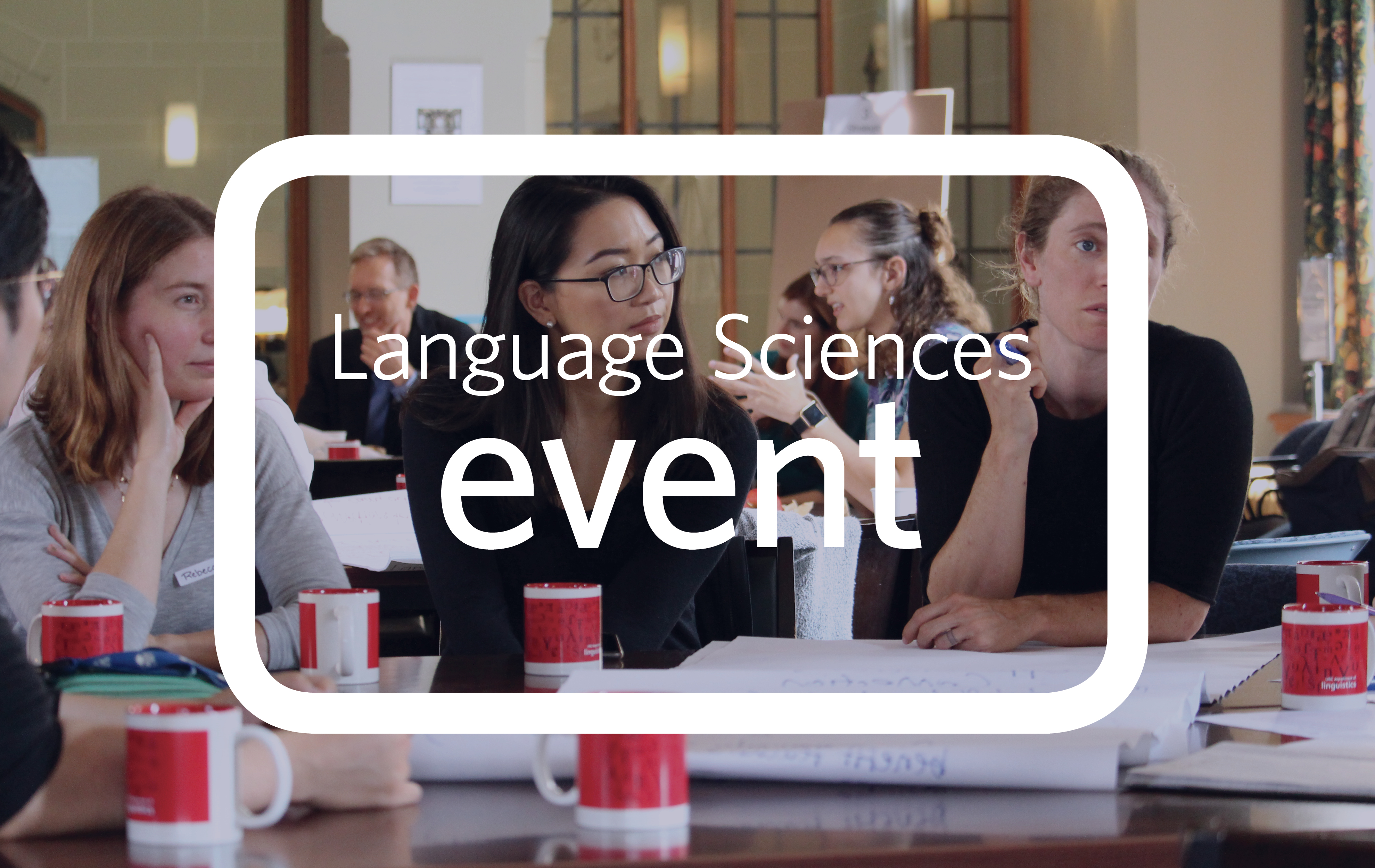 A picture of two members listening to a third speaking while holding a marker pen. In the foreground are red cups and poster paper