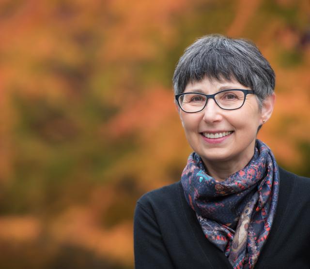 Headshot of Dr. Janet Werker. She is has short, dark hair, glasses and has a dark-coloured scarf around her neck. She is smiling.