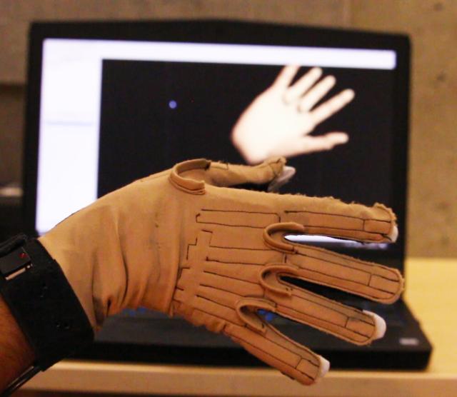 An image of the Cyberglove used to generate sound from movements, placed in front of a computer showing a 3D graphic of a hand