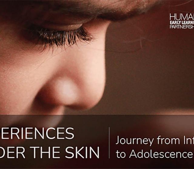 A close up of a childs face, including eyes and nose, looking down, with a brown background