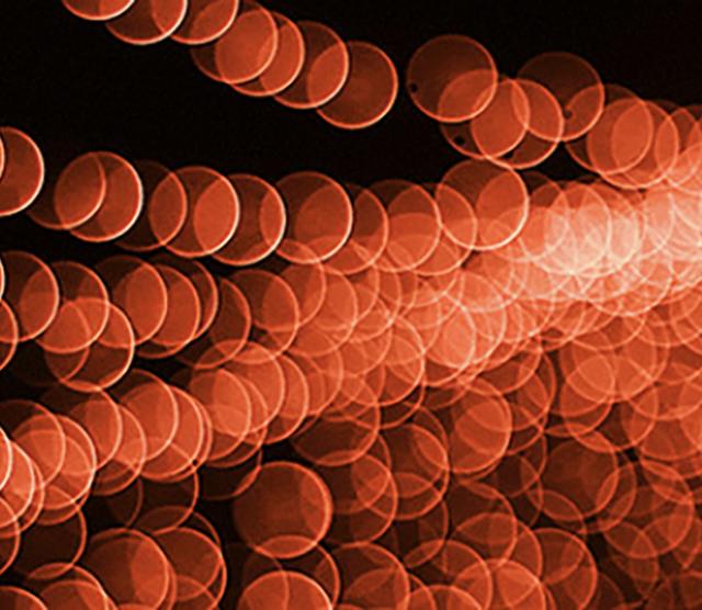 A picture of bubbles against a red background with a light shining from the right