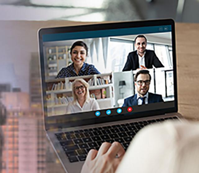 An image of a person using a laptop on which four people are taking part in a video call