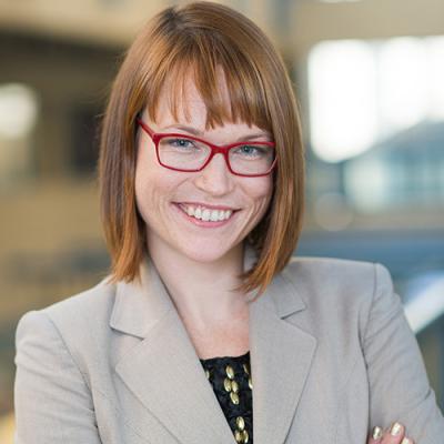 A headshot of Kiley Hamlin standing with arms crossed inside the UBC Psychology building