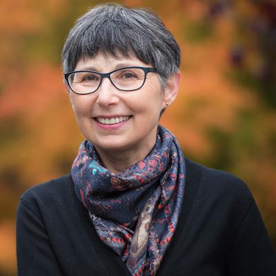 A headshot of Janet Werker standing outside and wearing a scarf