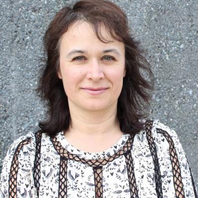 A headshot of Stefka H. Marinova-Todd standing in front of a wall.