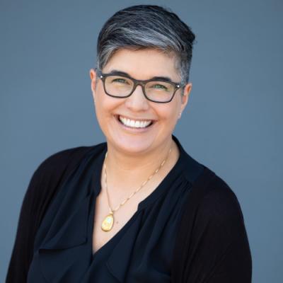 A headshot of Sara Davidson standing in front of a grey background