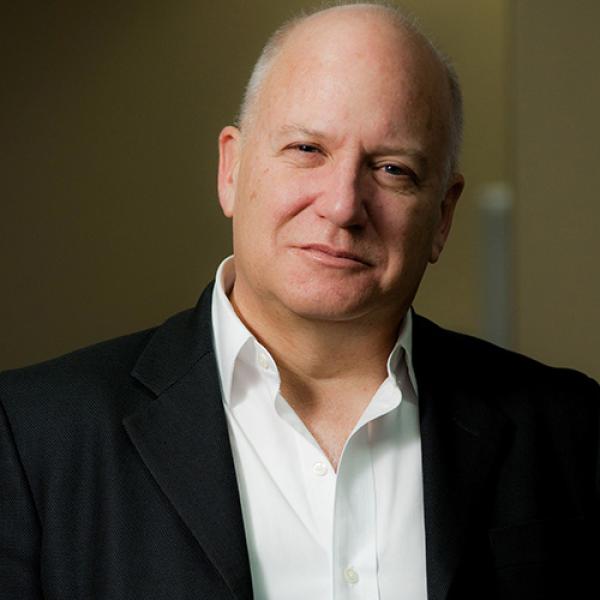 A headshot of Anthony Bailey standing in front of a brown background
