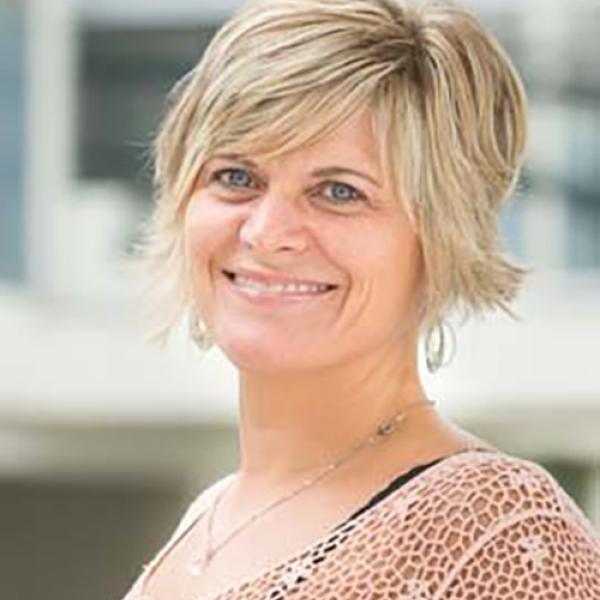 A headshot of Orr-Álvarez smiling, standing side on to the camera