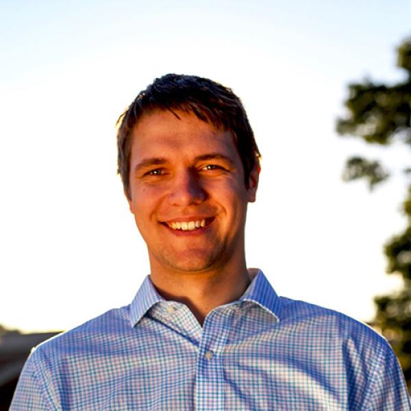 A headshot of Gasper Begus standing against the sky.