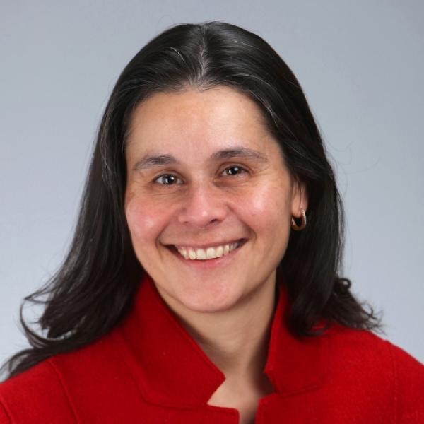 A headshot of Helene Deacon smiling and wearing a red jumper