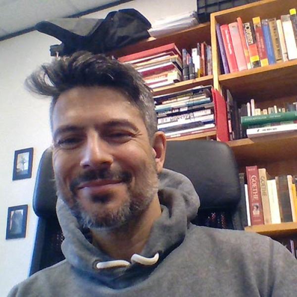 A headshot of Jason Lieblang sitting in front of a bookcase