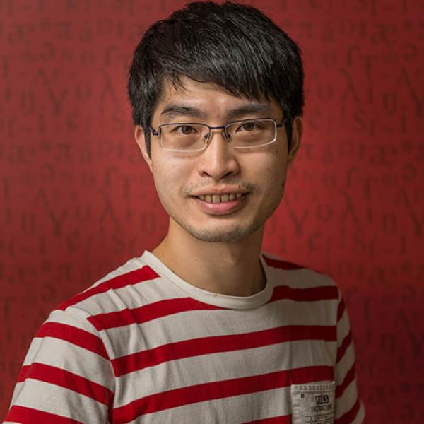 A headshot of Roger Lo smiling, and wearing a striped shirt