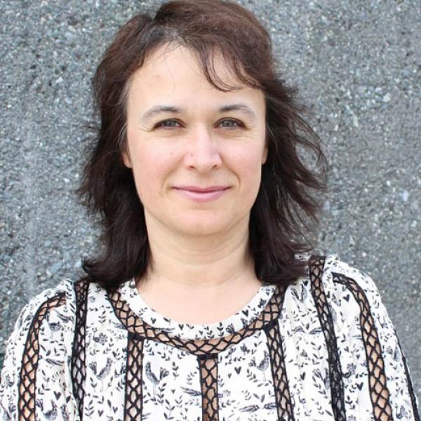 A headshot of Stefka H. Marinova-Todd standing in front of a wall.