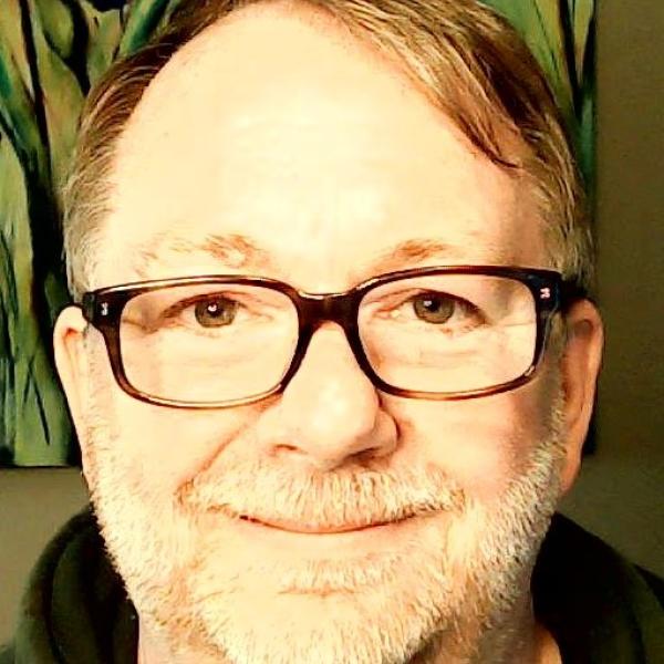 A headshot of Neil Leveridge wearing glasses