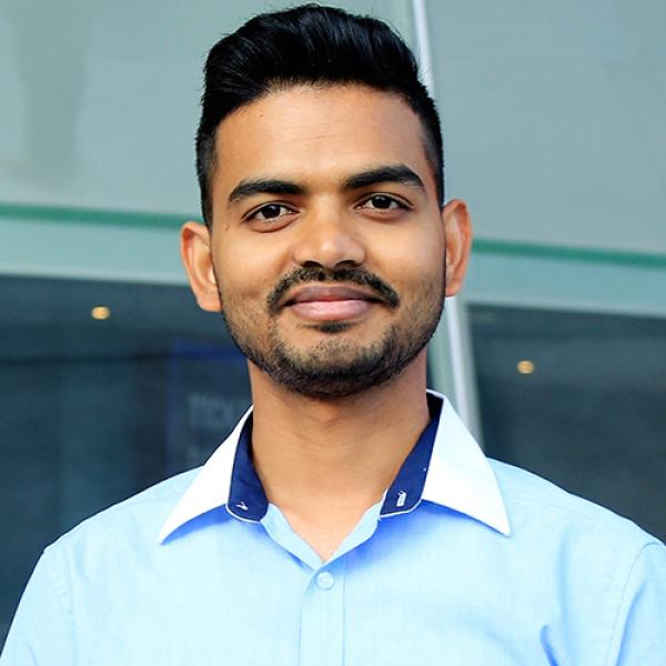 A headshot of Pramod Sah standing in front of a building