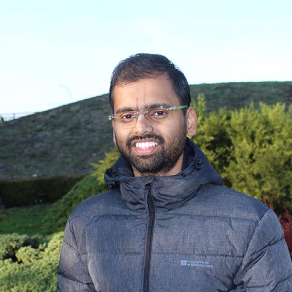 A headshot of Pramit Saha standing outside