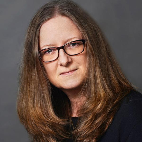 A headshot of Sherri K Zelazny against a grey background