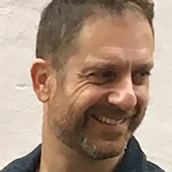 A headshot of Ori Simchen with face turned to the right