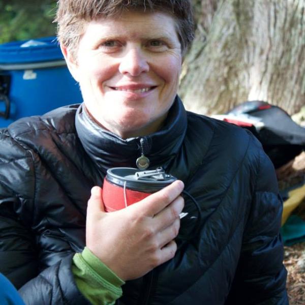 A headshot of Sonya Bird smiling and holding a mug