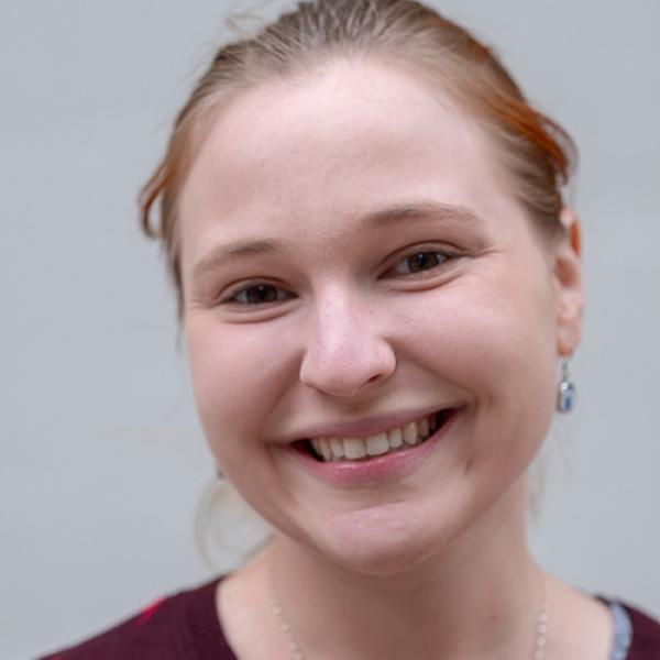 A headshot of Shannon Ward standing against a grey background