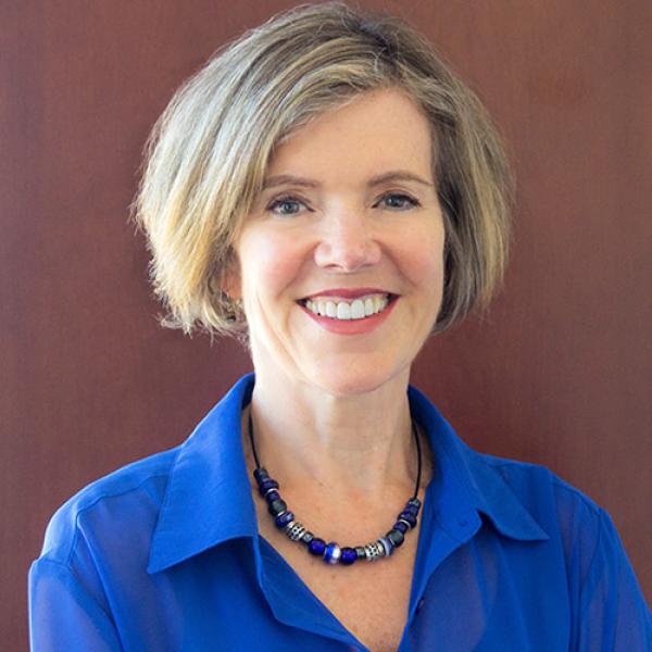 A hadshot of Wendy Carr against a brown background